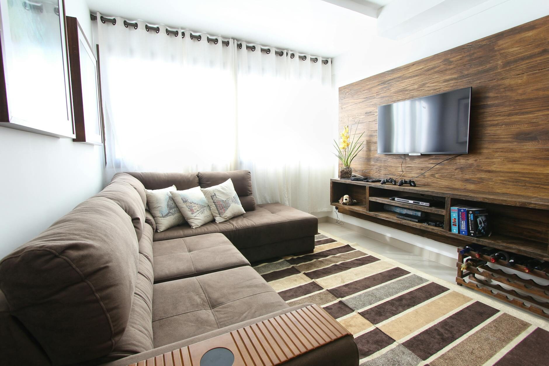 Living room with a wall-mounted TV on a warm wood panel